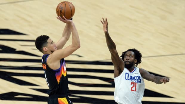 Jun 22, 2021; Phoenix, Arizona, USA; Phoenix Suns guard Devin Booker (1) shoots over LA Clippers guard Patrick Beverley (21) during the first half of game two of the Western Conference Finals for the 2021 NBA Playoffs at Phoenix Suns Arena. Mandatory Credit: Joe Camporeale-USA TODAY Sports